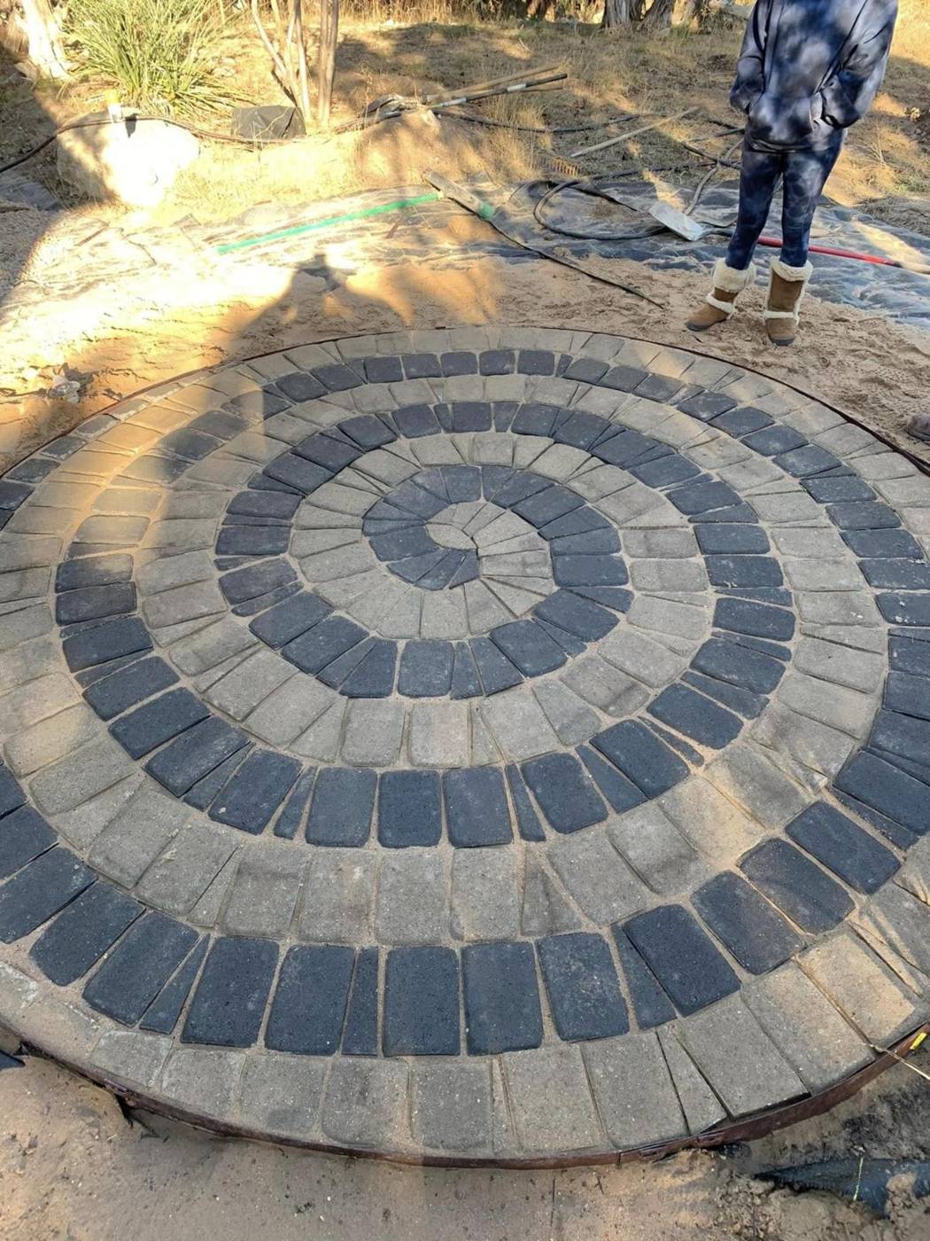 Circular paver patio laid in a two-tone spiral pattern