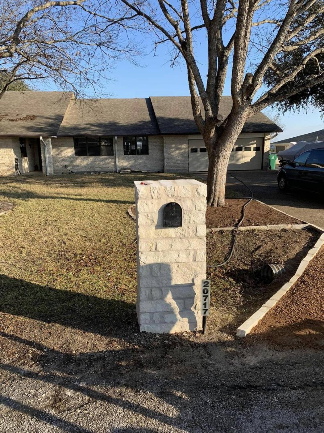 Custom limestone mailbox with a new stone-edged flower bed