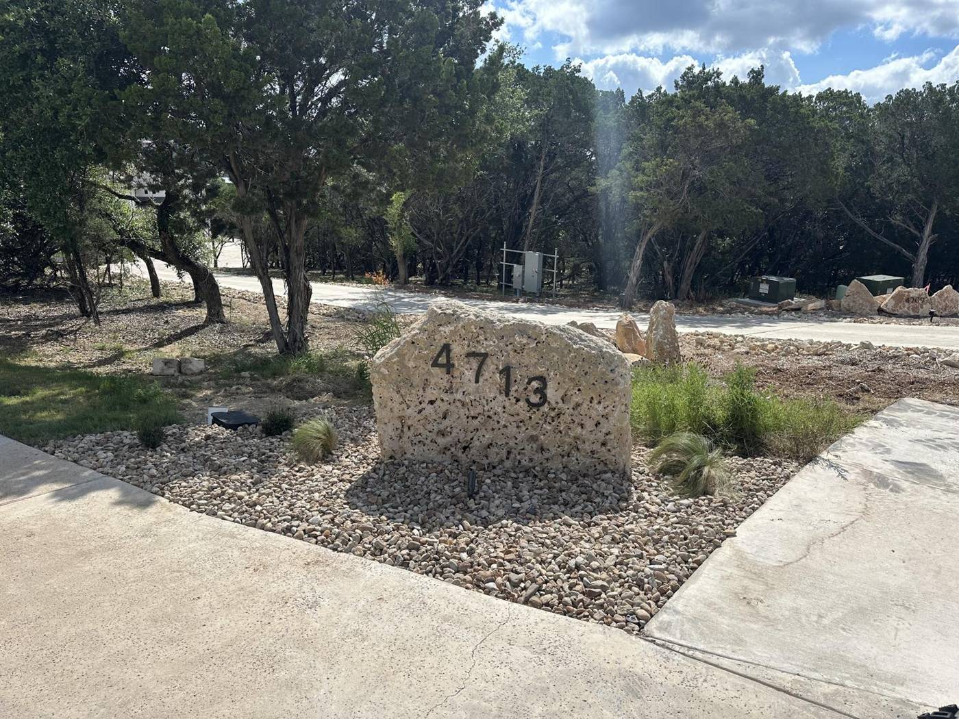 Engraved limestone address boulder in a xeriscape entry bed