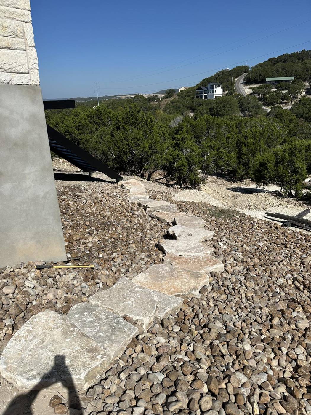 Flagstone stepping-stone path through river rock with a Hill Country lake view