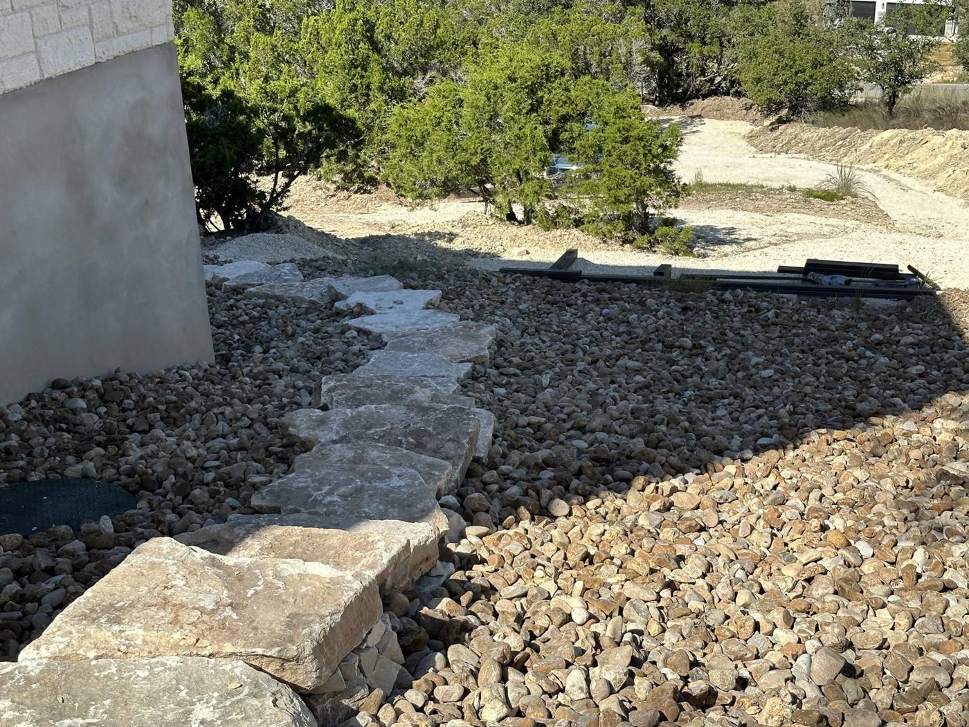 Limestone slab path and boulder steps through river rock xeriscape